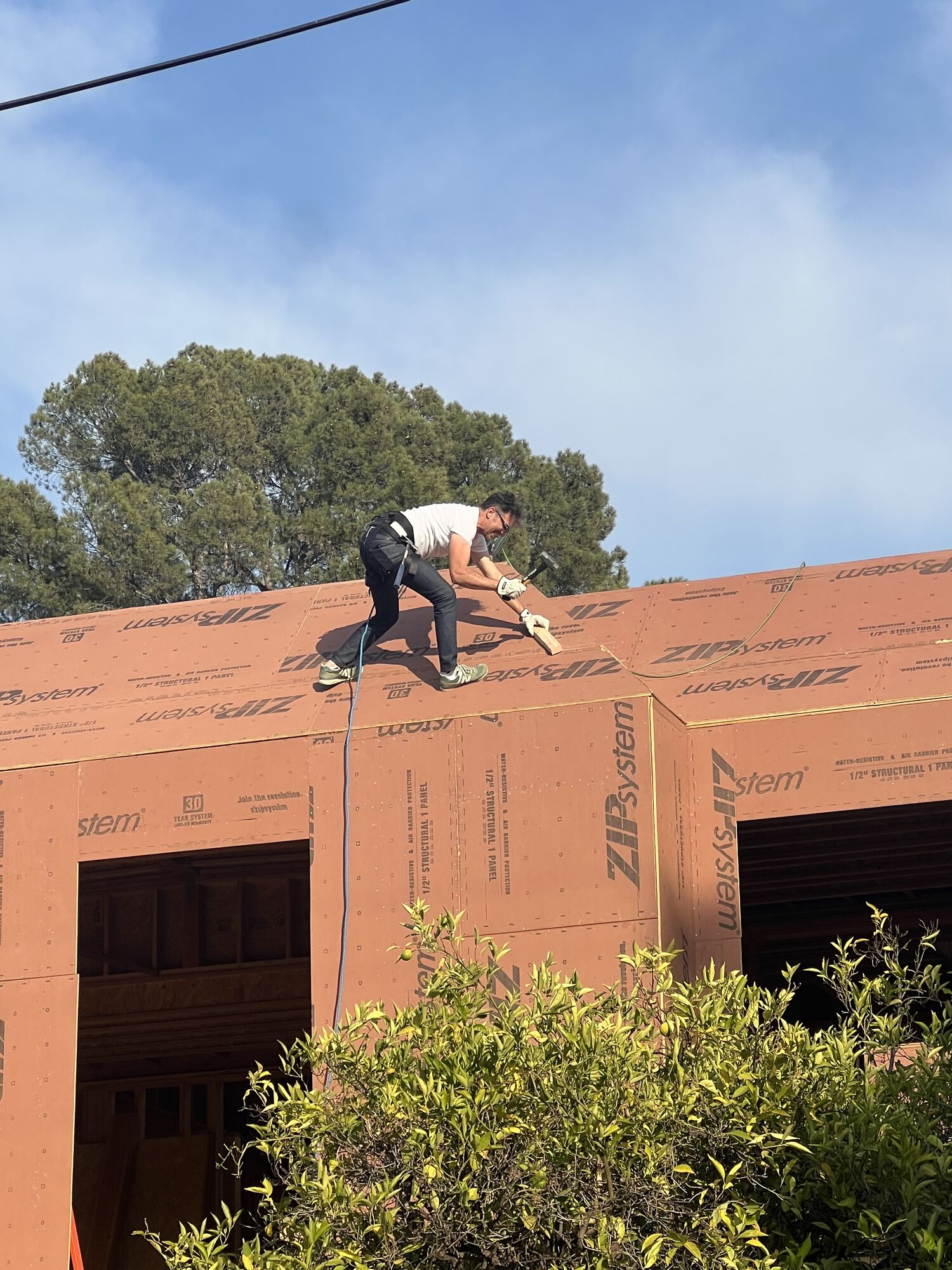 Unhappy about some nailing, the protagonist slips on his climbing gear and grabs a hammer