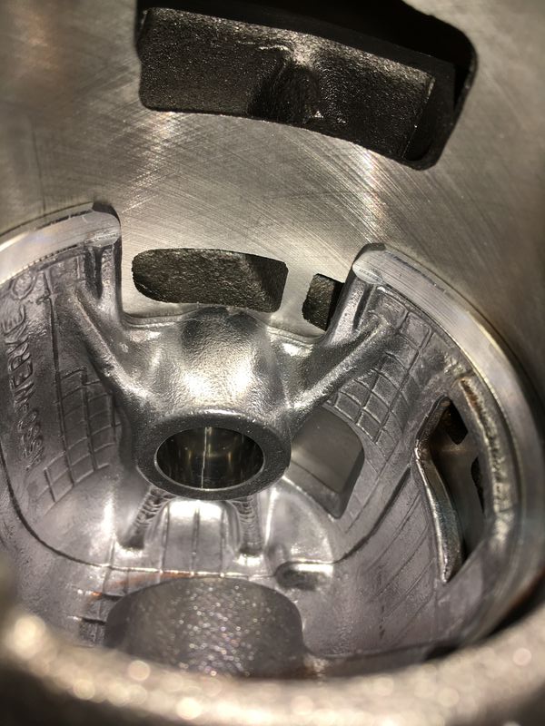At "vritual" TDC (piston flush with current cyl deck)  side skirt cut out aligns with transfer ports - as does hole near skirt (see next pic)