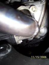 Take the scorpion and attach the pipe to the exhaust opening using the same two nuts to the bolts.