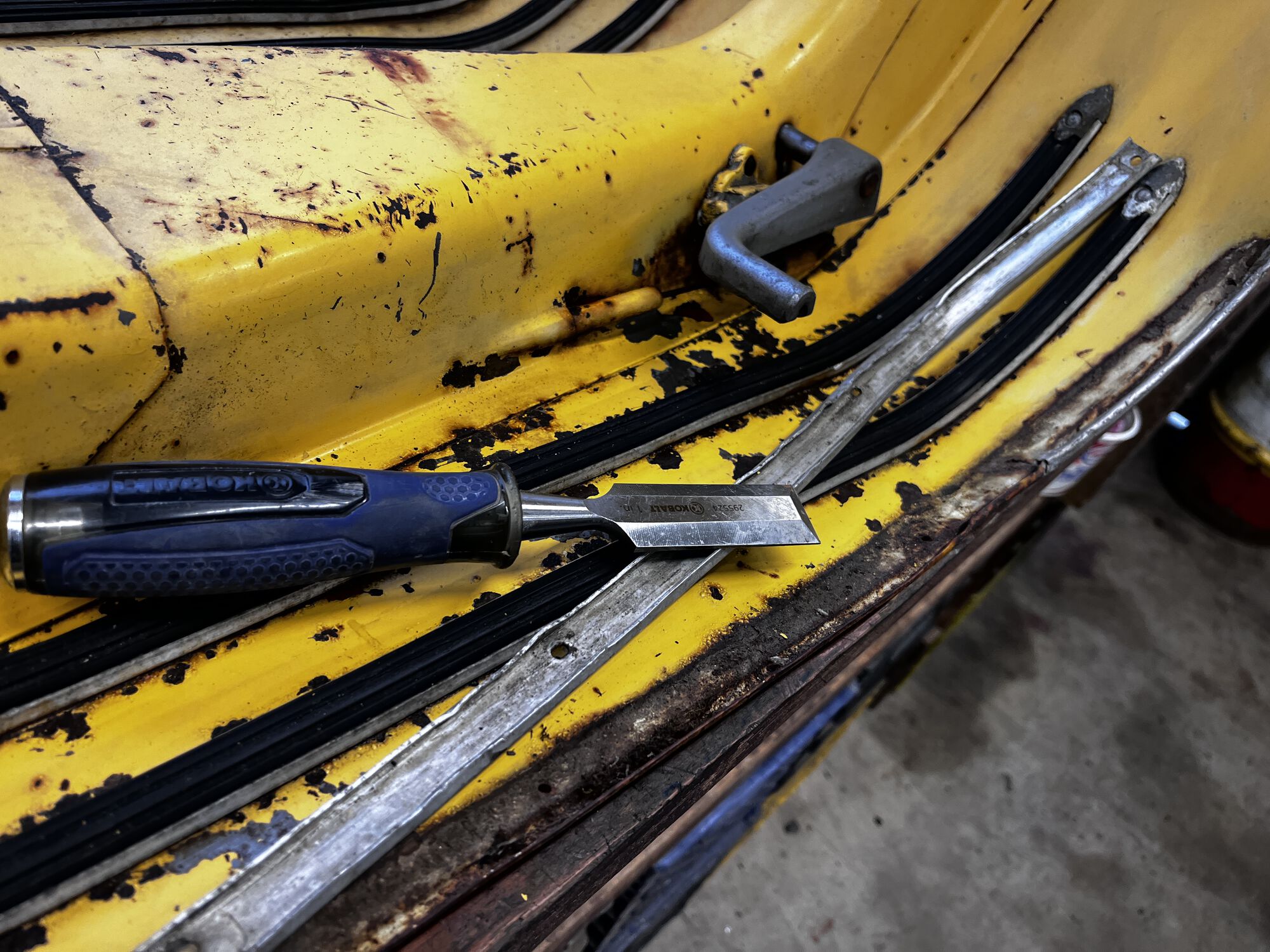 Floor rails being removed. I cut the bottom of the rivets off with the chisel, then they pop right off.