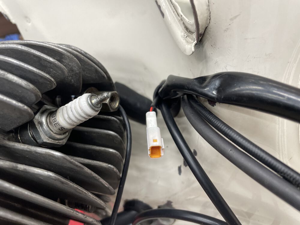 I ran both cables thru the frame to exit with the main harness at the engine. Note the CHT connector, and the smaller Tacho lead wire just to the left