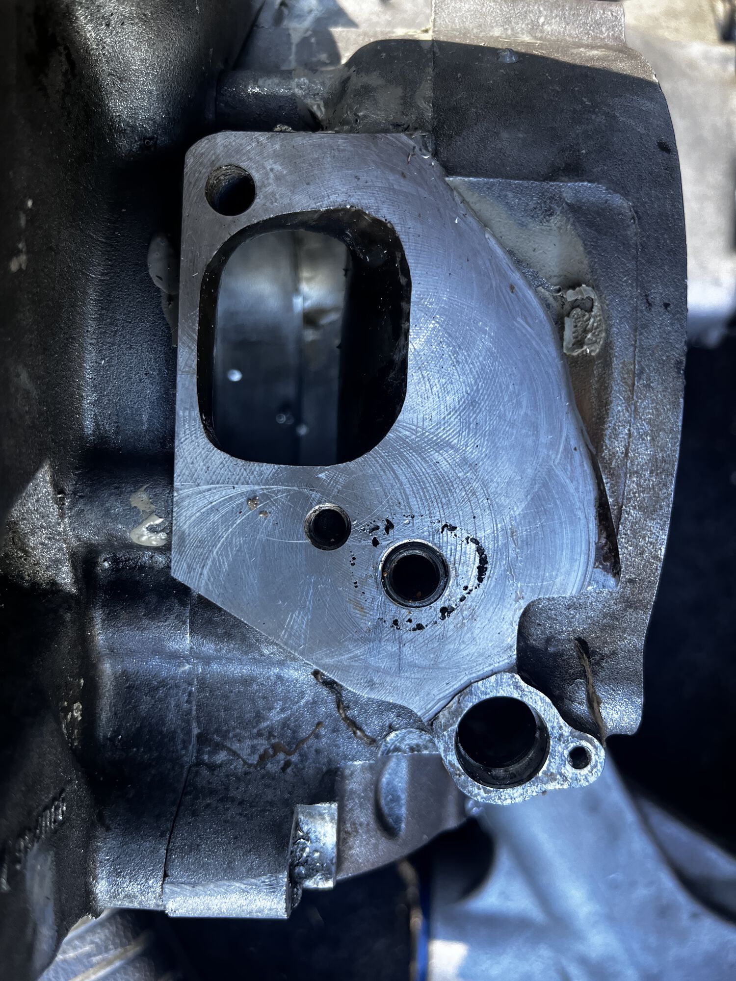 smooth flat surface with threaded insert for the carb stud. the insert is deeper than original, to allow for a longer stud/bolt into the case