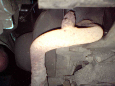 The rusty exhaust, looking towards the back of the bike.