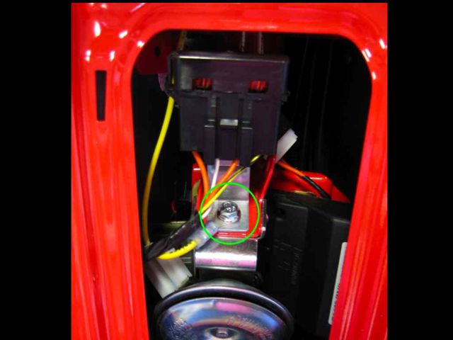 I couldn't find a ground connection I liked in the handlebar area.  So I ran the yellow ground wire (I'm a former boat owner -- it's hard not to use yellow as my ground color) down to this bolt above the horn, behind the front panel.