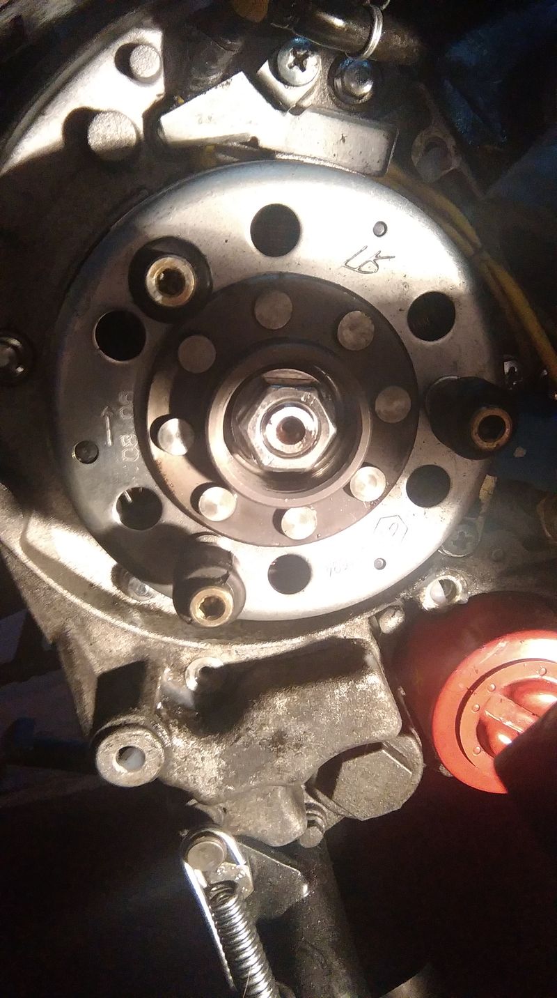 with the locator pins in the flywheel. it takes a bit of maneuvering. Leave the black plastic water pump cover off and turn it by hand to get the holes and the pins to line up....