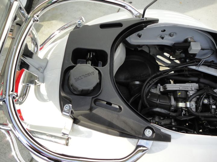 Undo the four bolts on the seat-latch/tank filler cover...