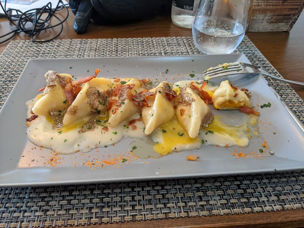 Gnocconi stuffed with squash, drizzled with carbonara sauce, and topped with truffle shavings