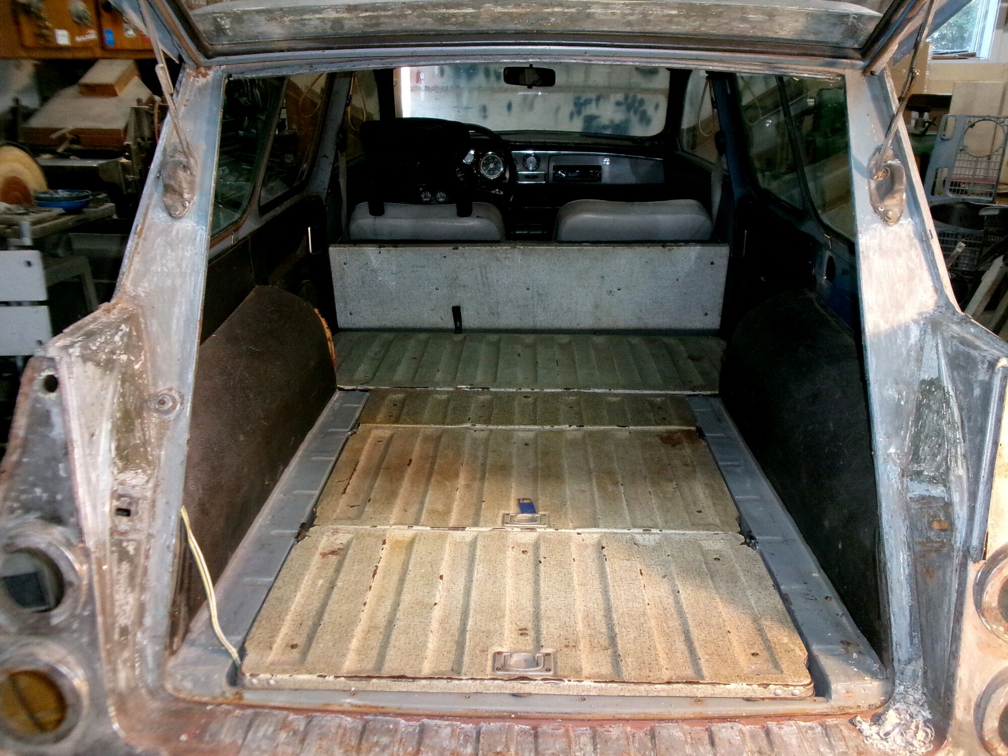 There's a rear-facing seat with storage under the back panel. If I pull the rear seat bottom and the passenger seat I can close the rear door on a 9' board.
