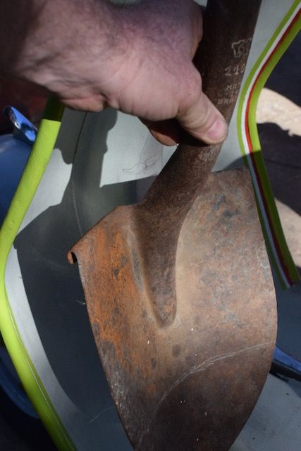 rusty shovel next to frame.