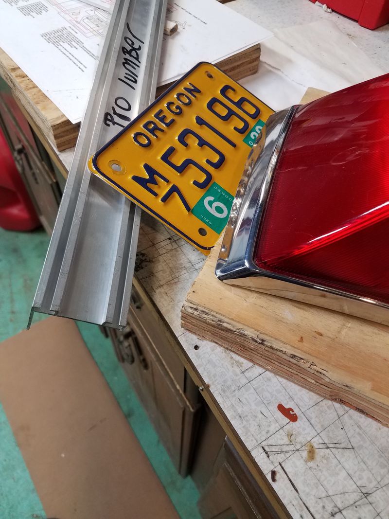 This is some leftover aluminum garage door base that just happens to have channels that are exactly the spacing of the three holes of the tractor light mounting. Should work nicely to mount the license plate.