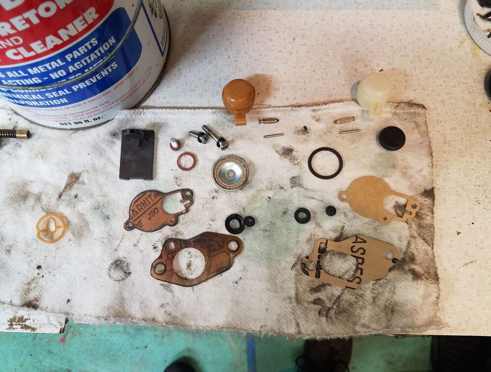 Old carb vs new carb gaskets. notice the old black tip float bowl needle. The carb and metal bits are in the chem dip.