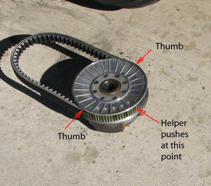 Place the assy on the ground, as shown.
You press on the lower pulley, toward the ground.