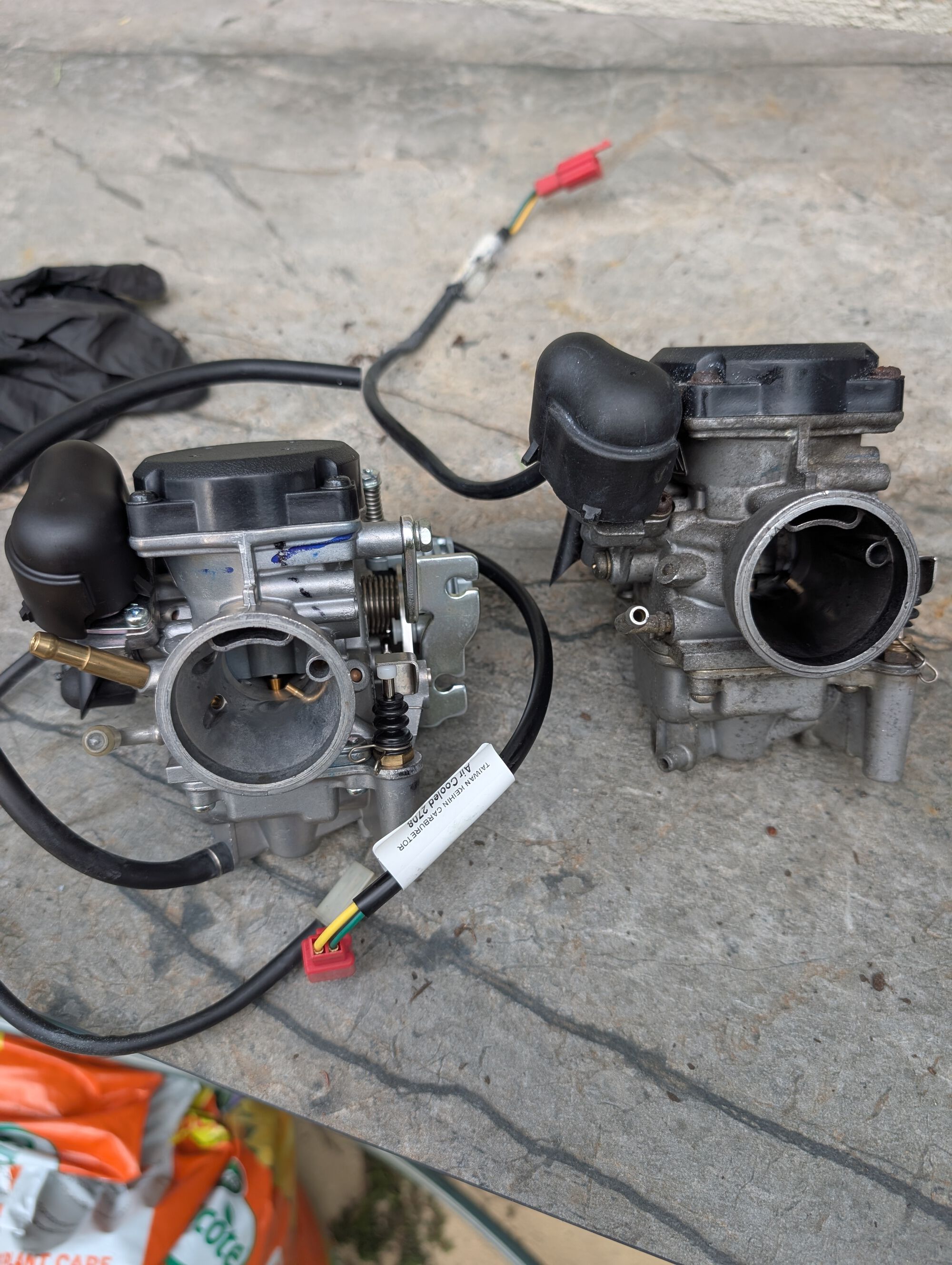 old  carburettor on right