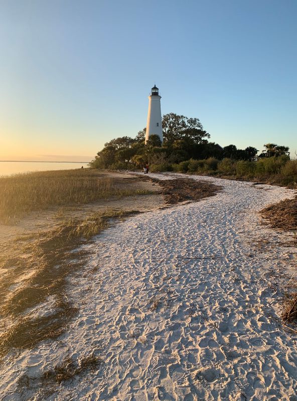 The lighthouse bathed in beautiful light as the sun set.